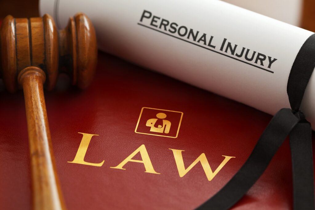 rolled up paper that says "personal injury" on table with mallet and the word law inscribed
